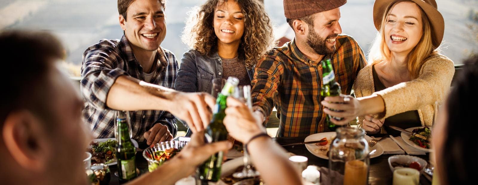 Gruppe junger Leute auf einer Terrasse die sich zuprosten